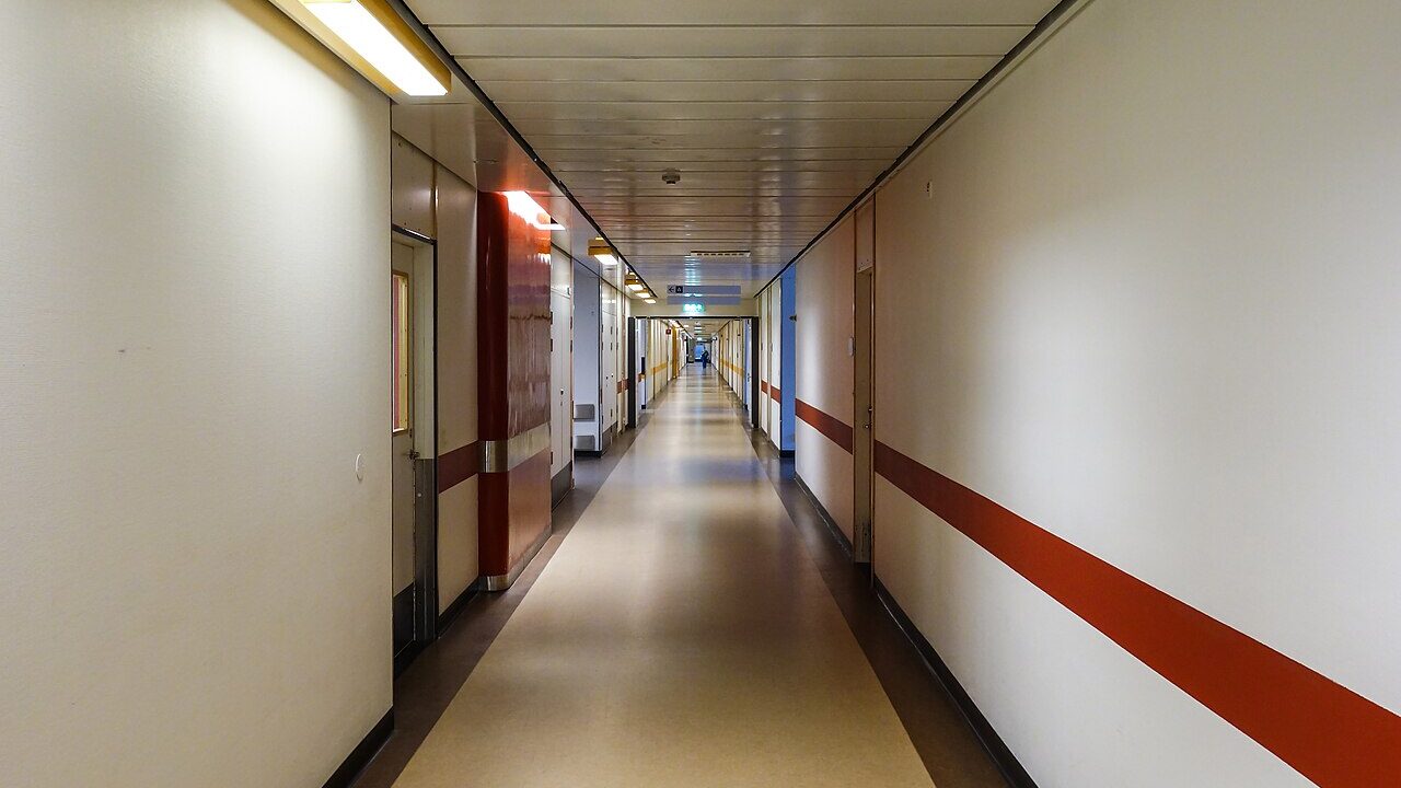 Corredor de hospital vazio com portas de quartos
